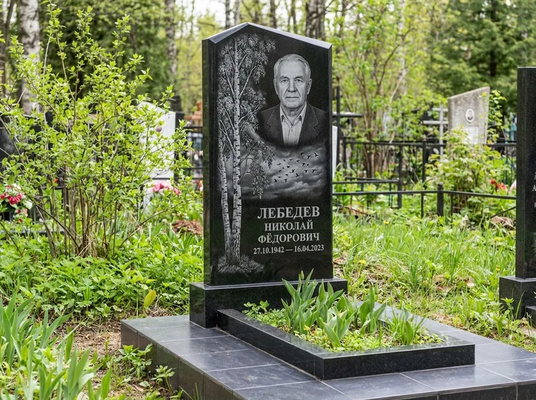 Памятник с гравировкой берёзы: вертикальная стела со скошенным верхом — берёза и стая птиц в небе, гранитный цоколь с тёмной плиткой, работа «Лебедев» в Нижнем Новгороде