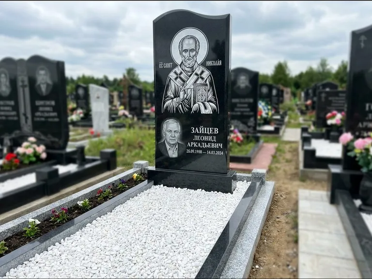 Памятник с гравировкой иконы: стела с крестообразным навершием — икона в резной рамке-киоте, газон без ограды, стриженая трава, работа «Раевская» в Нижнем Новгороде