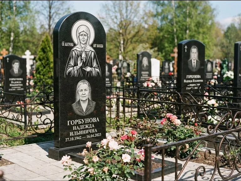 Памятник с гравировкой иконы: стела с арочным верхом и киотом под образ — гравировка образа Матроны Московской, гранитный цоколь с тёмной плиткой, работа «Ковалёв» в Нижнем Новгороде