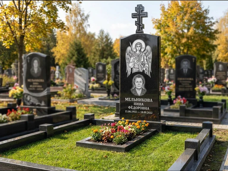 Памятник с гравировкой иконы: округлая стела-медальон с ликом — гравировка Богородицы «Семистрельная», луговые травы и полевые цветы за участком, работа «Гущин» в Нижнем Новгороде