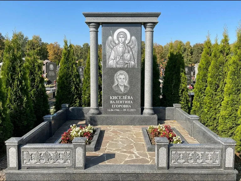 Памятник с гравировкой иконы: массивная стела с двускатным навершием-домиком — гравировка Николая Чудотворца, живая изгородь из туи, работа «Журавлёв» в Нижнем Новгороде