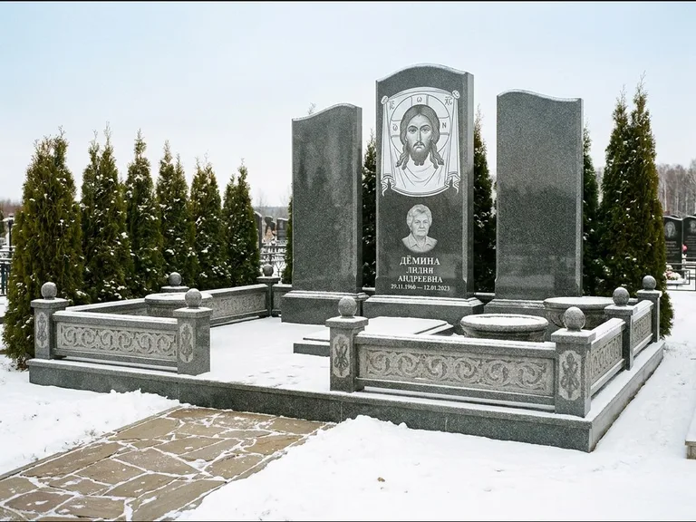 Памятник с гравировкой иконы: узкая вертикальная стела-пилон с ликом — икона в резной рамке-киоте, открытая лужайка без ограды, работа «Одинцов» в Нижнем Новгороде