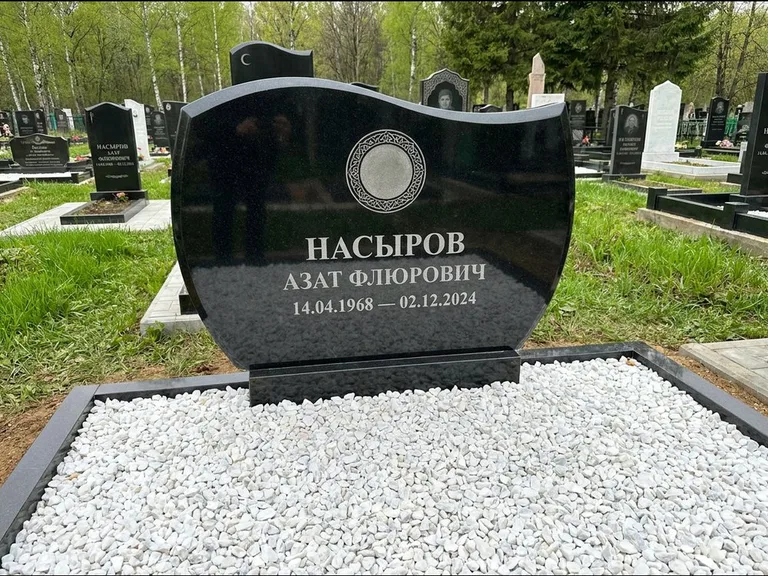 Мусульманский памятник: стела с волнообразным скошенным верхом — гравировка мечети под полумесяцем и звёздами, белая мраморная крошка с бордюром, работа «Насыров» в Нижнем Новгороде