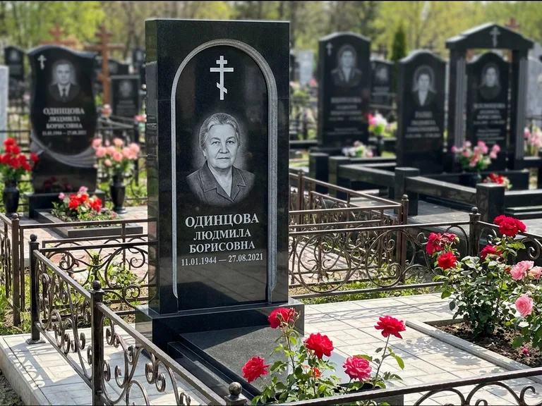 Памятник из чёрного гранита — скромная невысокая стела с крестом с терновым венцом, работа «Лаврентьева» в Нижнем Новгороде
