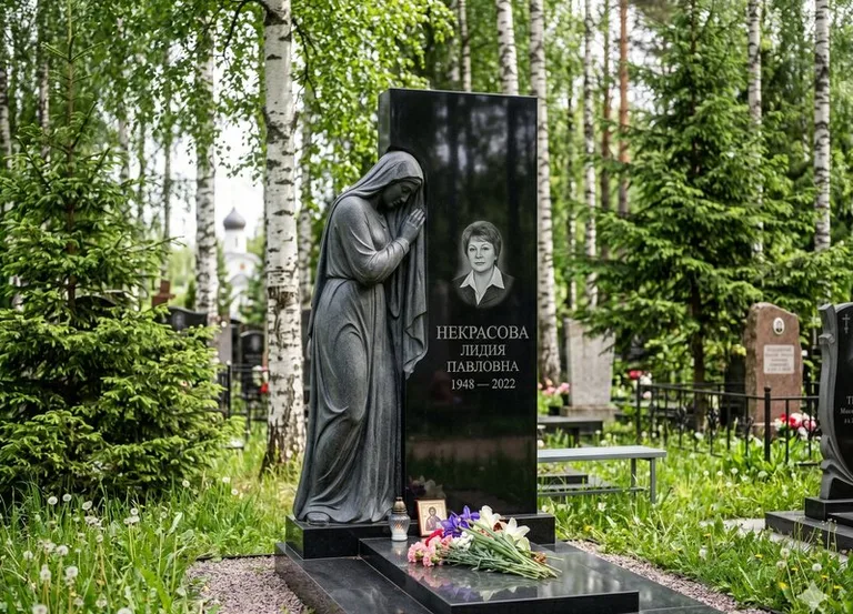 Гранитная фигура скорбящего мужчины у чёрной стелы в Нижнем Новгороде