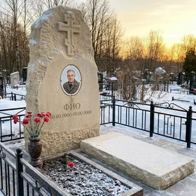 Памятник из светлого известняка в виде глыбы с крестом